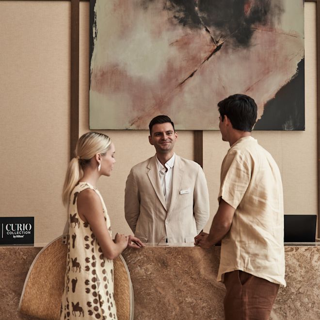 Couple Registering at the Front Desk in Lobby Area