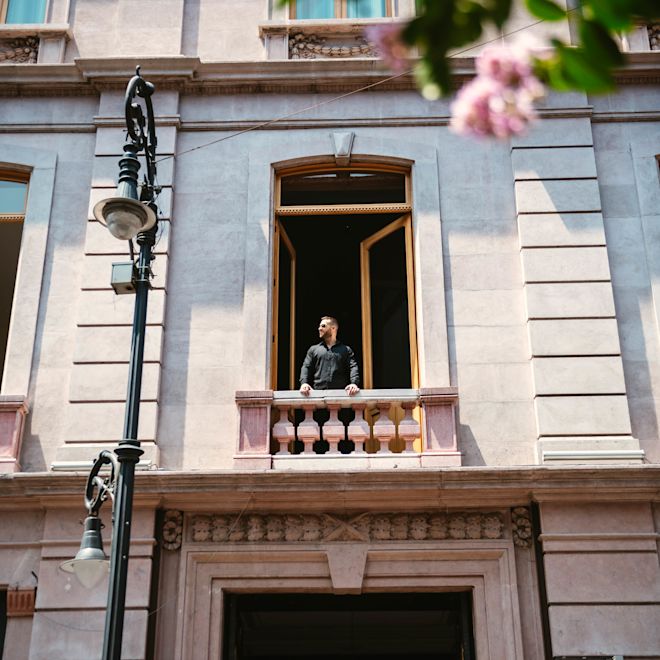 Man standing on hotel balcony looking out