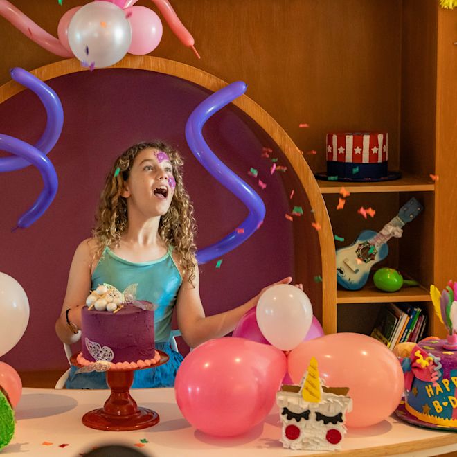 Girl Celebrating a Birthday with Chocolate Cake and Balloons at the Kids Club