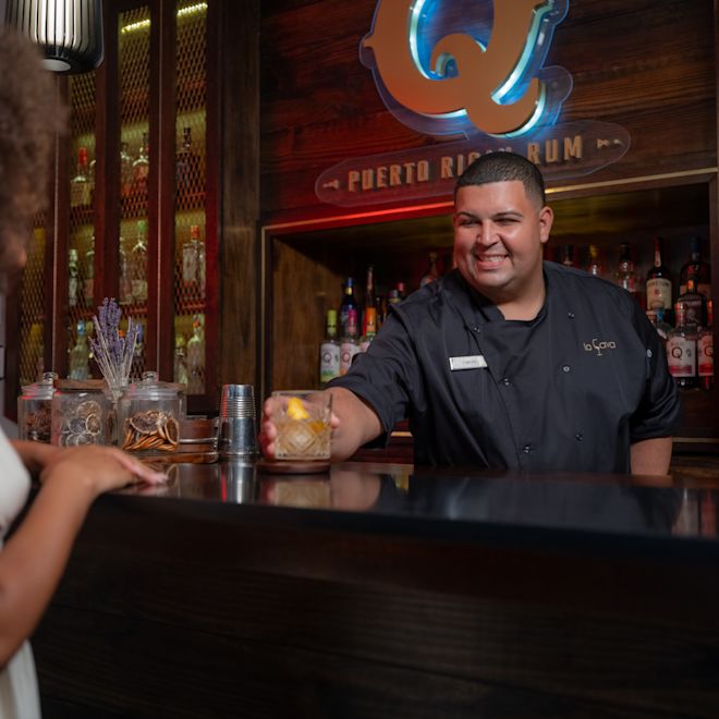 Bartender Serving a Drink to a Woman at La Cava Bar