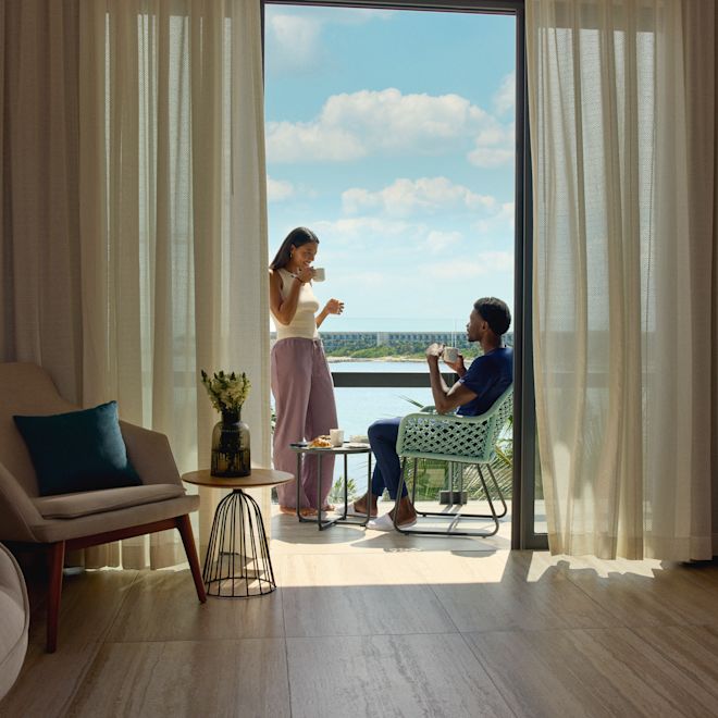 Un homme et une femme prenant un petit déjeuner sur la terrasse de leur suite
