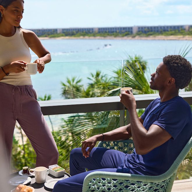 رجل وامرأة يشربان القهوة في شرفة جناحهما