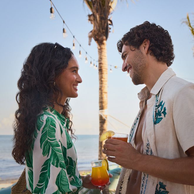 Man and woman with drinks at the Beach Club