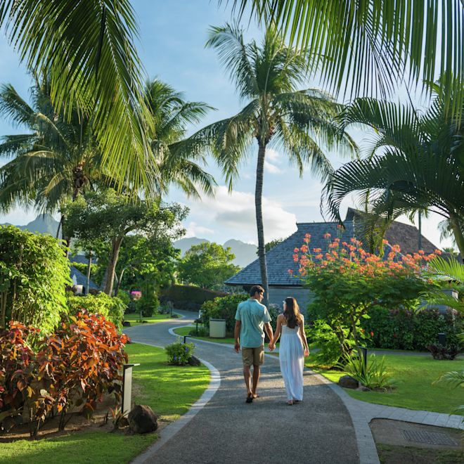 ホテル内のトロピカルガーデンを散歩するカップル