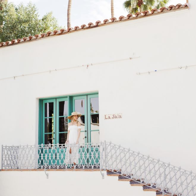 Woman standing outside white building
