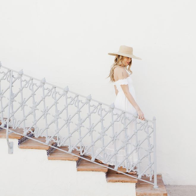Woman walking down stairs with hand on railing