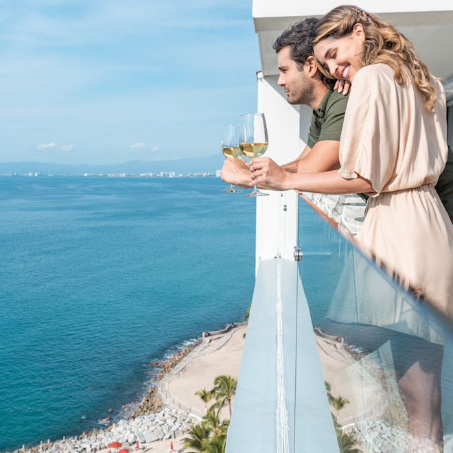 Couple sur le balcon d'une chambre buvant du vin
