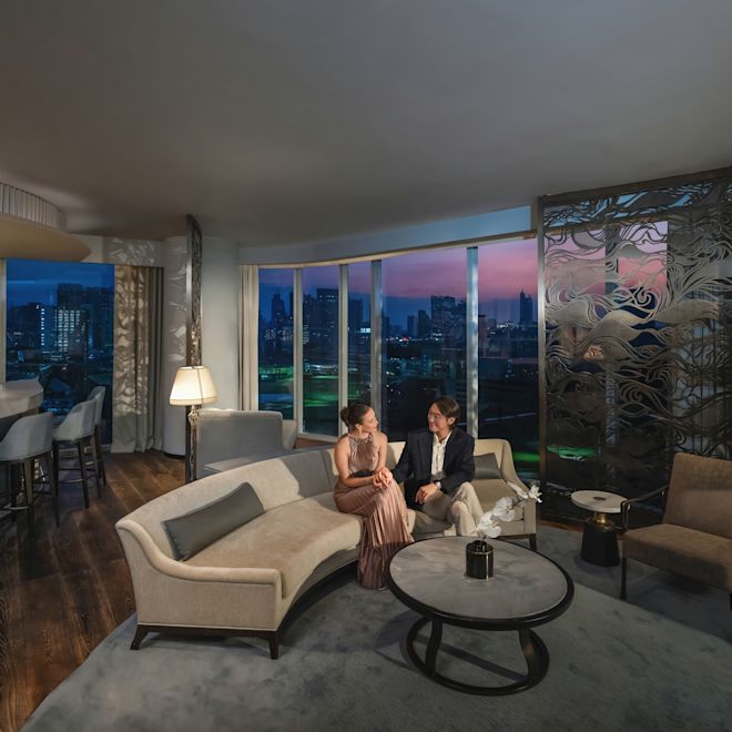Man and woman relaxing in comfortable seating area with city view