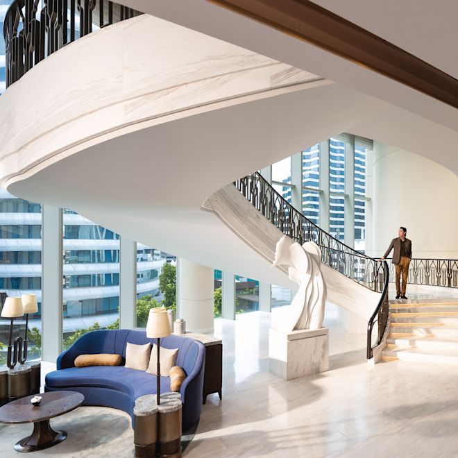 Large spiral staircase with person descending stairs into lobby area