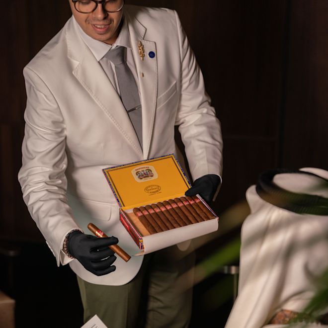 お客様に葉巻をお選びになるホテルのスタッフ