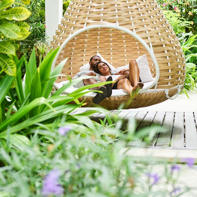 Un homme et une femme se détendant dans un grand fauteuil suspendu