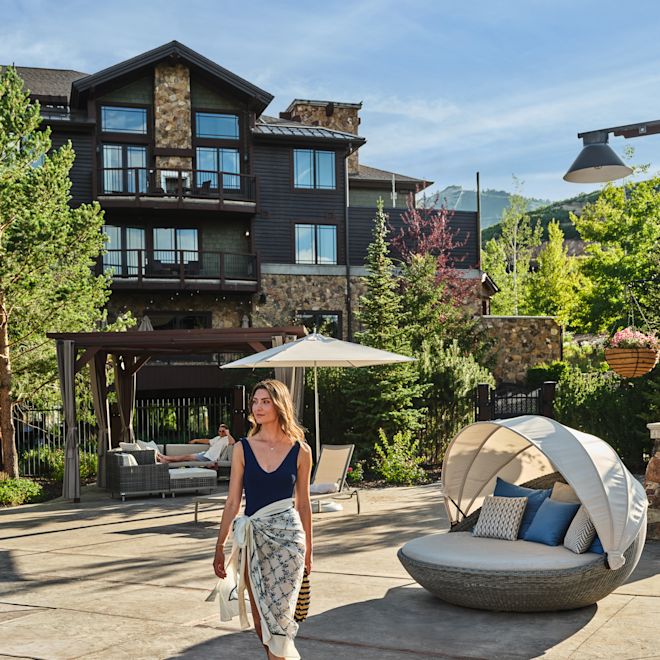 Femeie plimbându-se în zona piscinei în aer liber