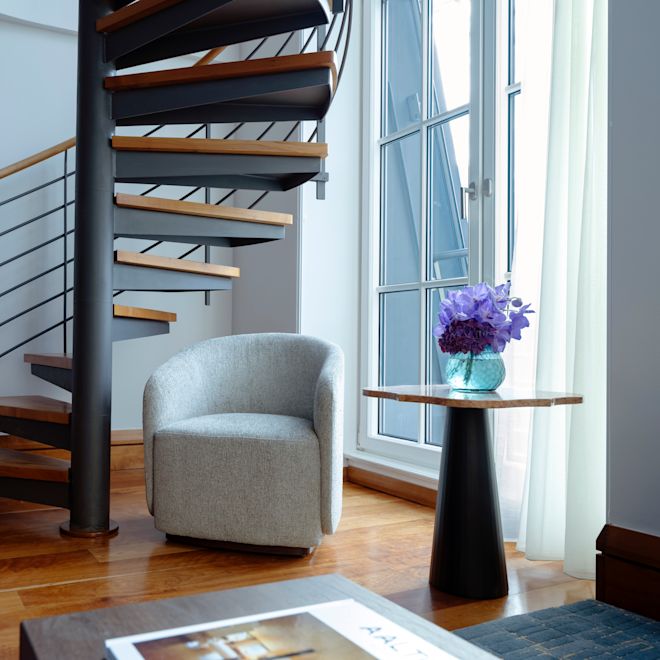 camera - Scala a chiocciola, poltrona, tavolo con fiori