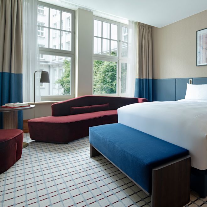 camera, un letto king size, divano, finestra con vista sugli alberi