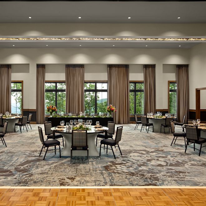 Skyline Ballroom set up for a banquet or reception with round tables, chairs, a head table and a dance floor.