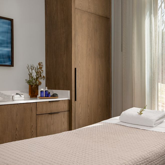 Spa treatment room with a table and cabinets.