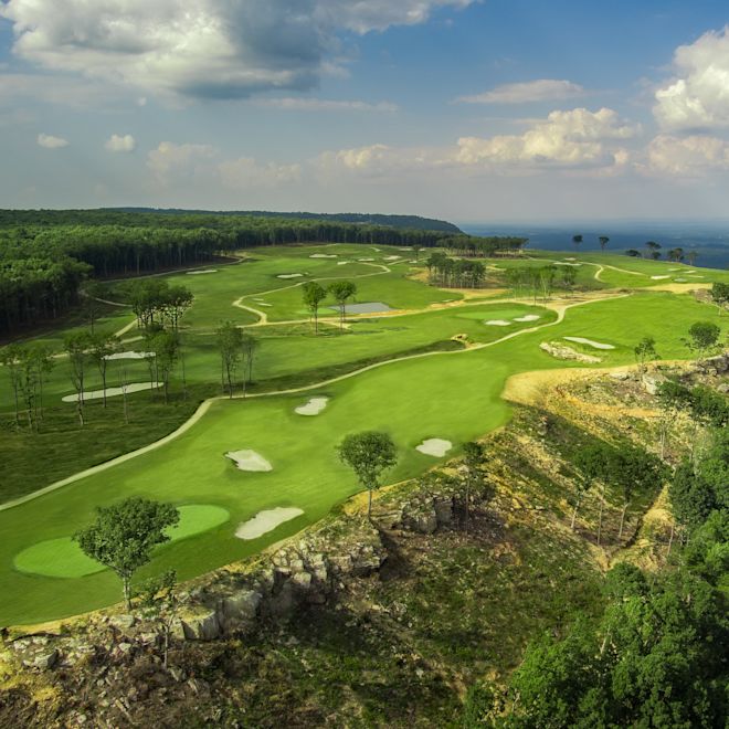 Aerial view of golf course with cliff edge and tree line