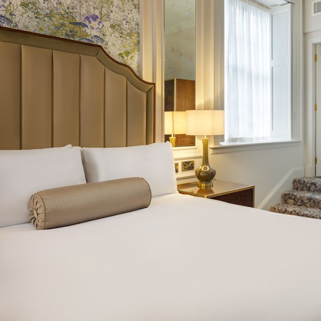 guest room, 1 queen bed , night table, lamp, stairs to bathroom