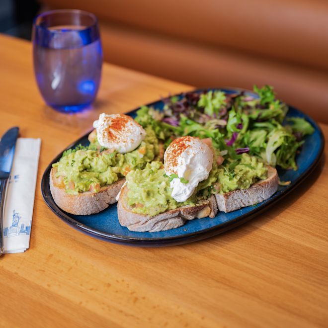 O farfurie cu salată și guacamole cu ou pe pâine la Carnegie Diner & Cafe