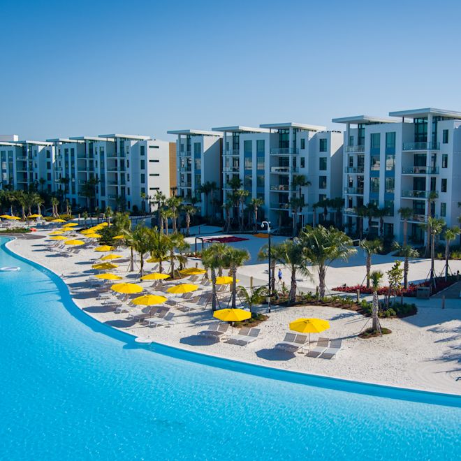 Luftaufnahme eines großen Gewässers mit Sitzgelegenheiten und Gebäuden