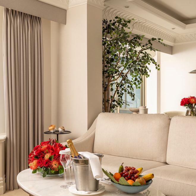 Champán, flores y frutas frescas en la sala de estar de la suite