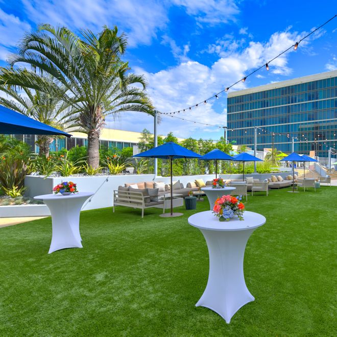 Saltflower Lawn Setup with Round Tables and Seating Area under Umbrellas