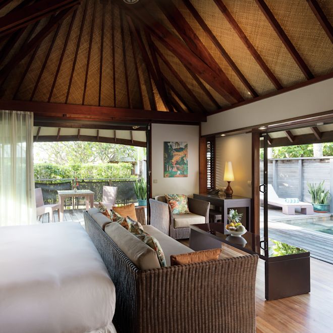 大きなベッドとソファを備えたプールビューの客室