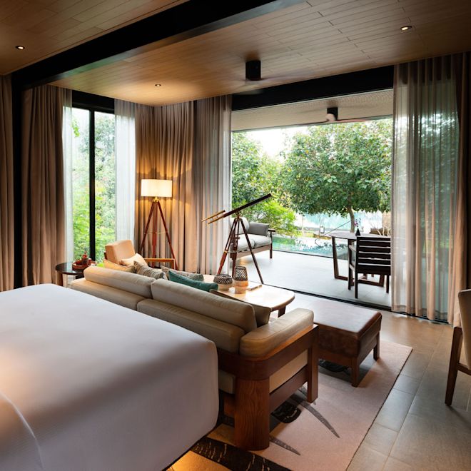 Suite Premium con una cama grande, sofá y piscina al aire libre