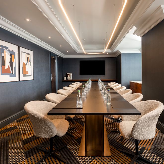 Disposición de la sala de juntas para una reunión de 14 personas y un televisor