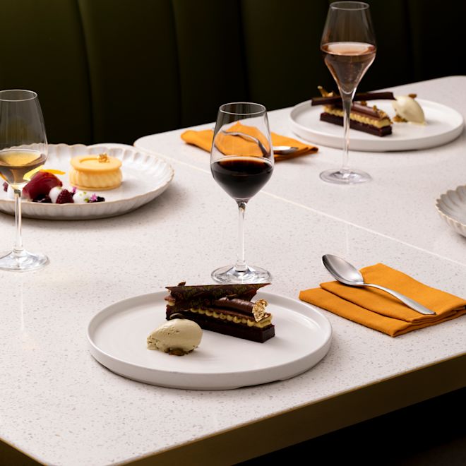 Pastel de arándanos, naranja y pistacho en un plato en Park Corner Brasserie