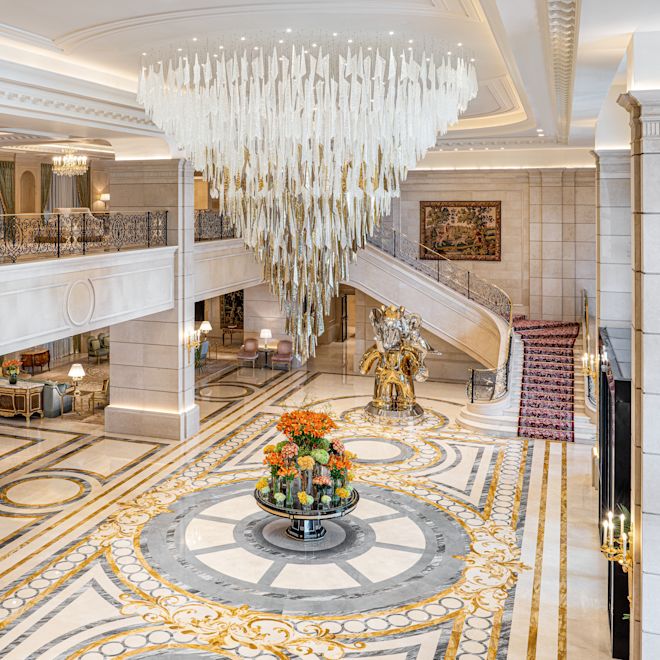 Lobby Area with Flowers, Stairs Leading to a Mezzanine and a Large Chandelier