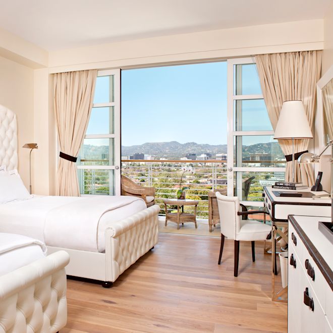 Two beds in room with work desk