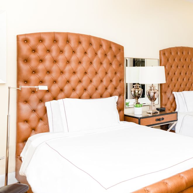 Two beds in room with art on wall