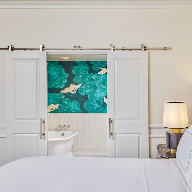 Suuri vuode ja osittainen näkymä kylpyammeeseen erillisessä kylpyhuoneessa