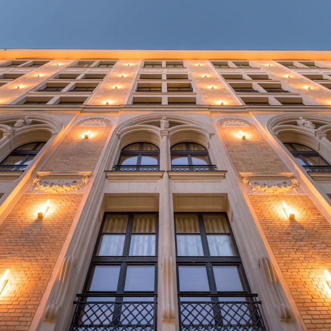 Exterior do hotel do térreo, com vista para as janelas e iluminação