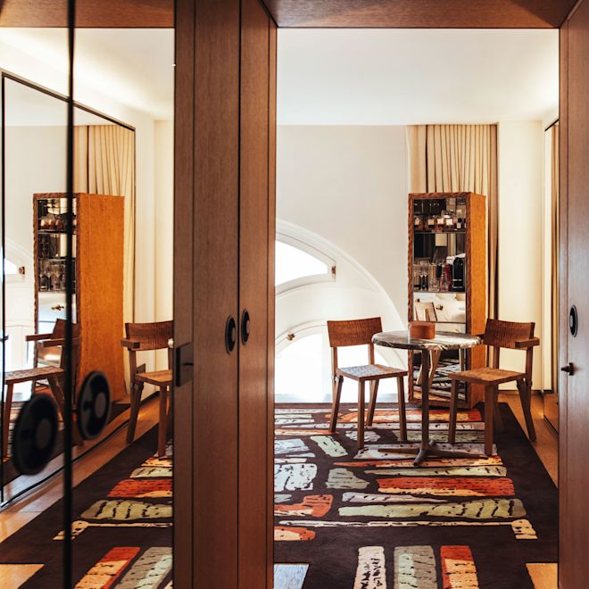 Pemandangan pintu menuju area lounge dengan meja kopi dan kursi