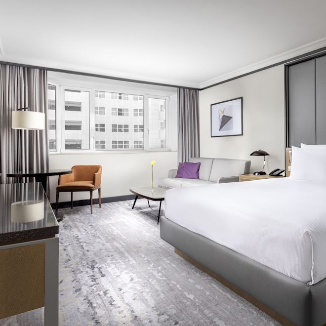 Family Deluxe Guestroom with Bed, Lounge Area with Sofabed, and Work Desk