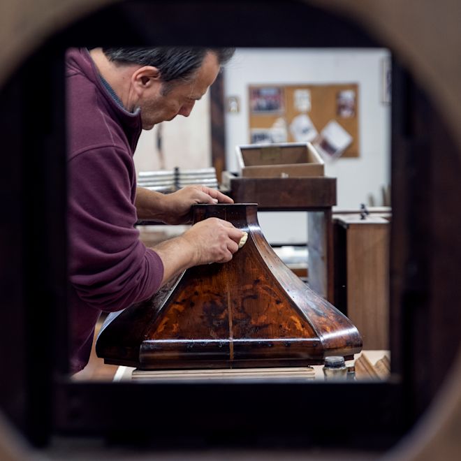 man working on the cabinet for the Waldorf Astoria lobby clock