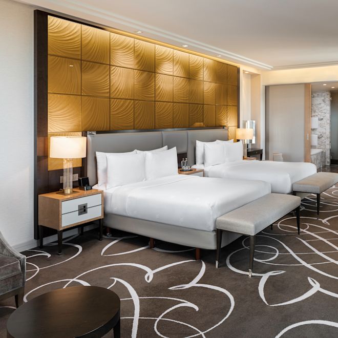 2 beds in room with table and chairs