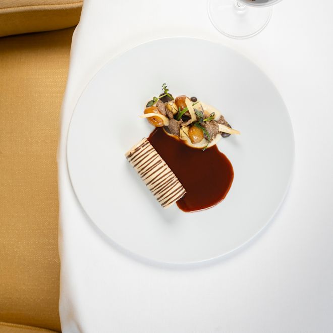 o băutură și o farfurie cu mâncare pe o masă la restaurantul Gordon Ramsay au Trianon