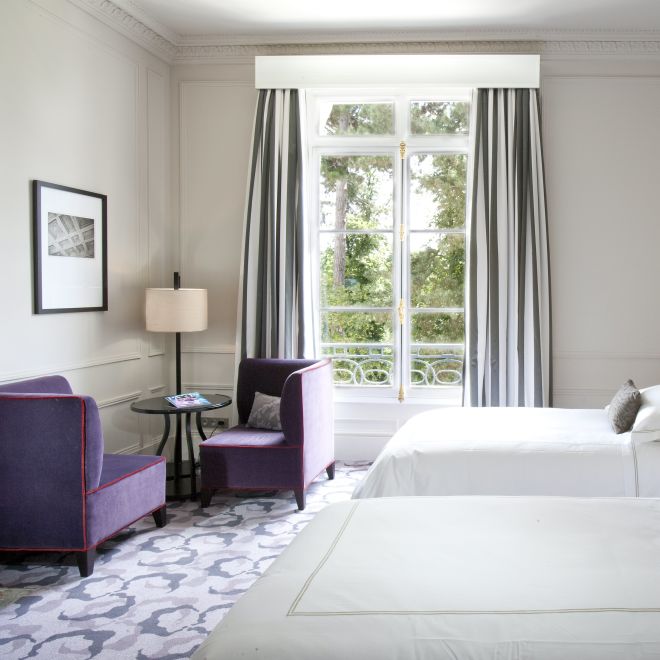 Two Beds in Hotel Room with Seating Area and Garden View