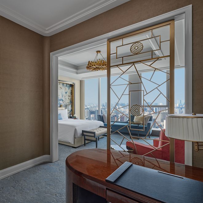 客房 1 张特大床和办公空间、浴室入口、窗外市景