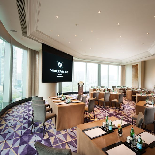 时代广场会议室配有桌椅、大型演示电视和可欣赏室外景观的落地窗