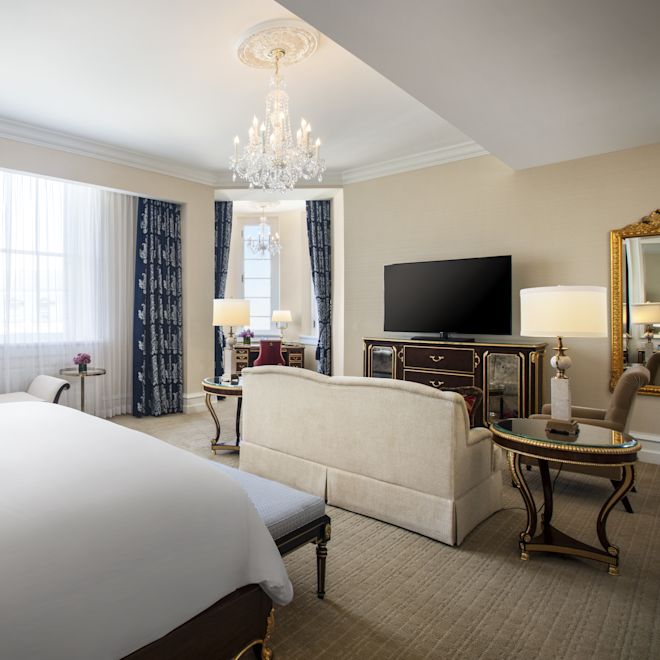 Junior suite bedroom and sitting area with sofa and TV