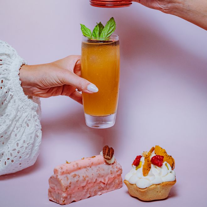 レドゥーでお飲み物を召し上がり、甘いお菓子を手にする女性