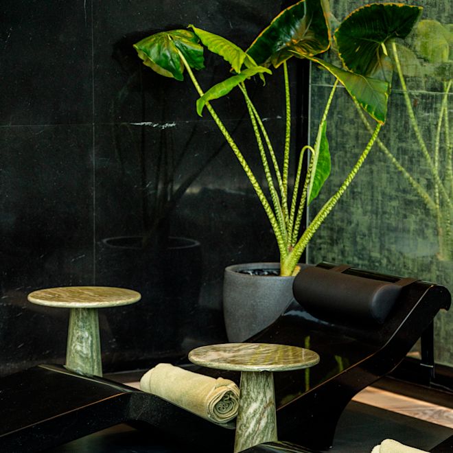 Chaises longues et petite table dans l'espace piscine