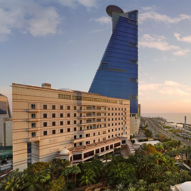 Impressive hotel building overlooking ocean at sunset