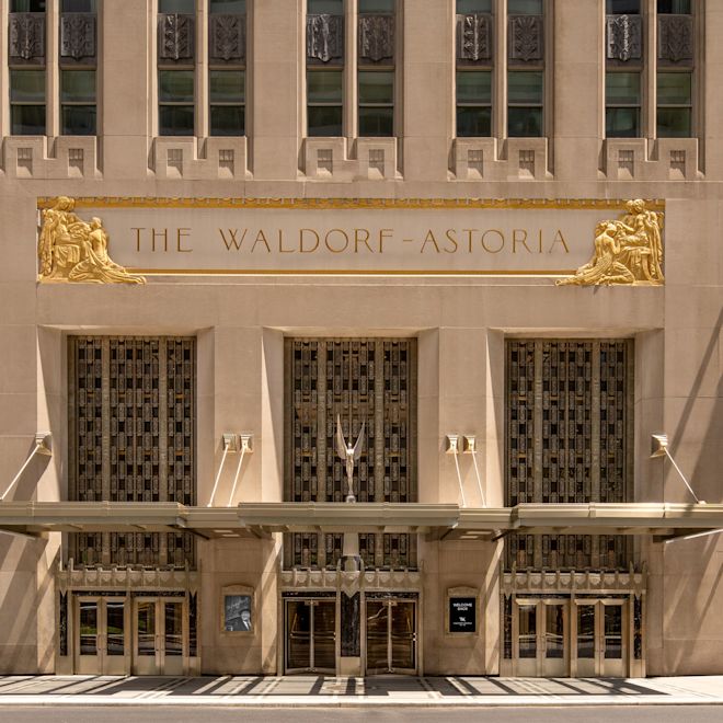 Hotel exterior with entrance and signage reading 'The Waldorf Astoria'