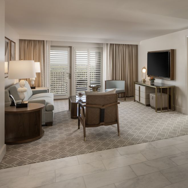 area lounge suite tamu, sofa, kursi lounge, tv, meja makan, pintu masuk kamar tidur