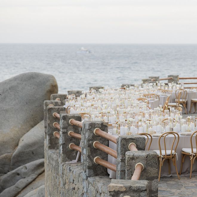 Mesas preparadas con velas para comer en una terraza